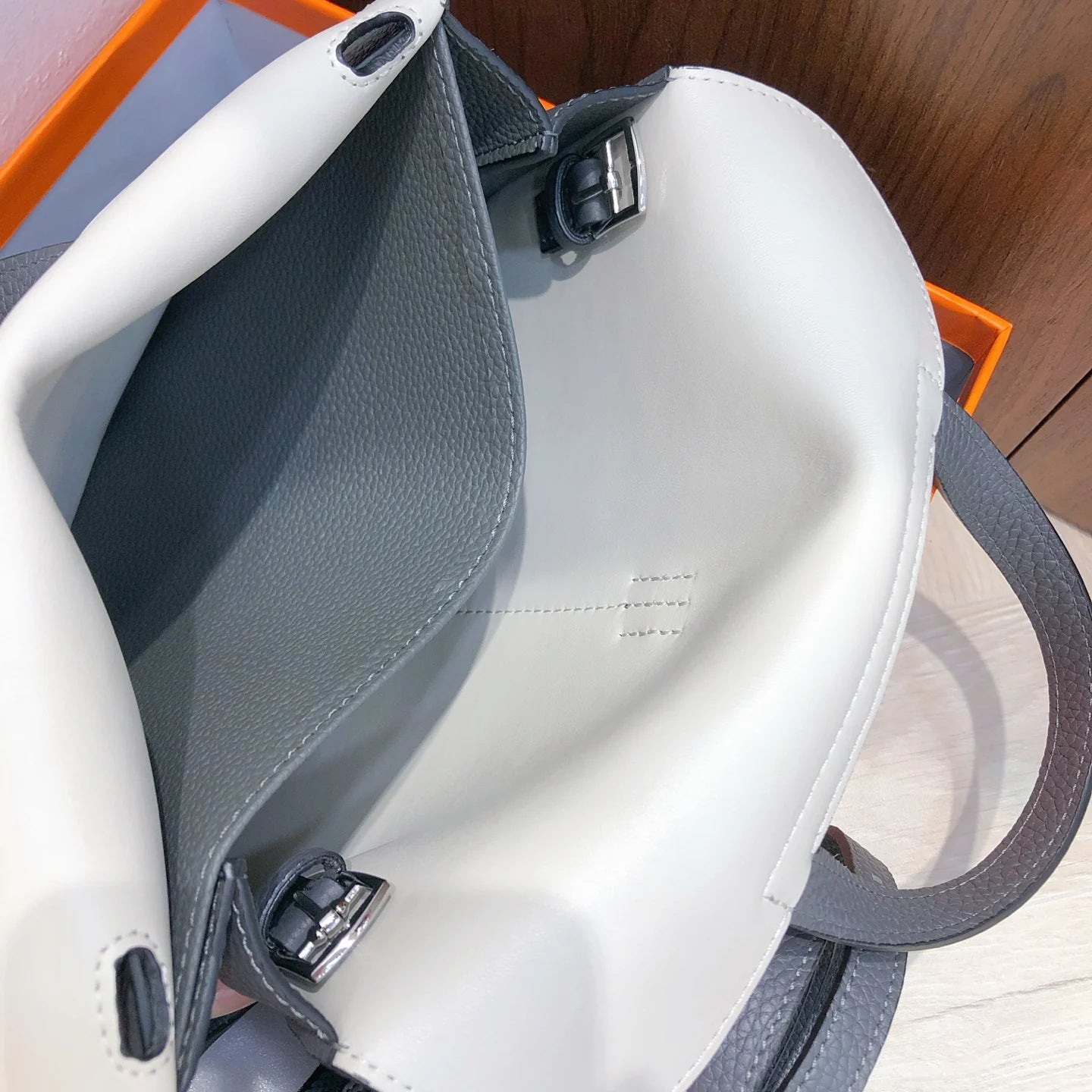 Halzan 25 features a design with graphite grey and white leather accents silver hardware