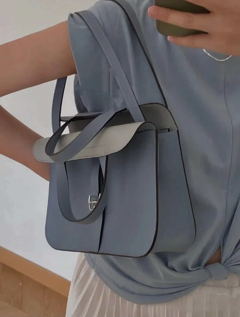 Halzan 25 features a design with graphite grey and white leather accents silver hardware