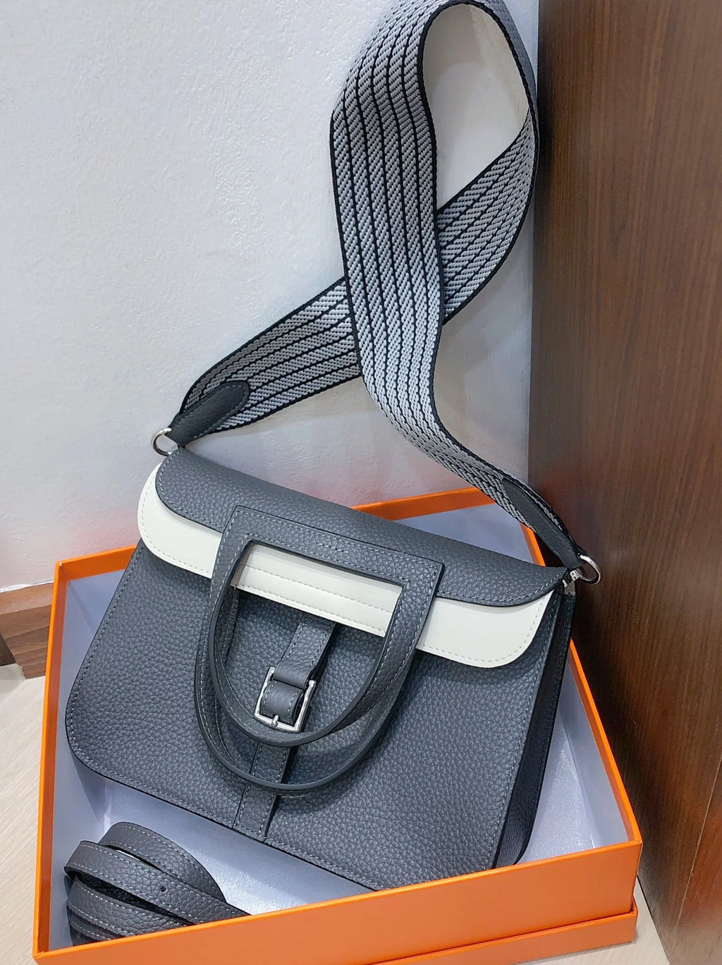 Halzan 25 features a design with graphite grey and white leather accents silver hardware