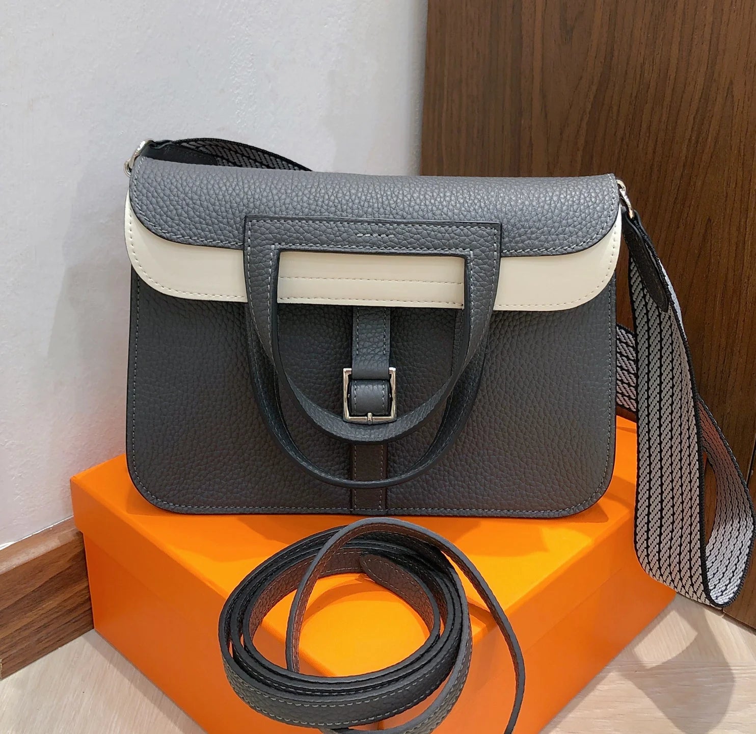 Halzan 25 features a design with graphite grey and white leather accents silver hardware
